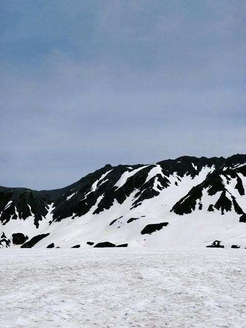 Snow-covered mountain ridge beneath an overcast sky