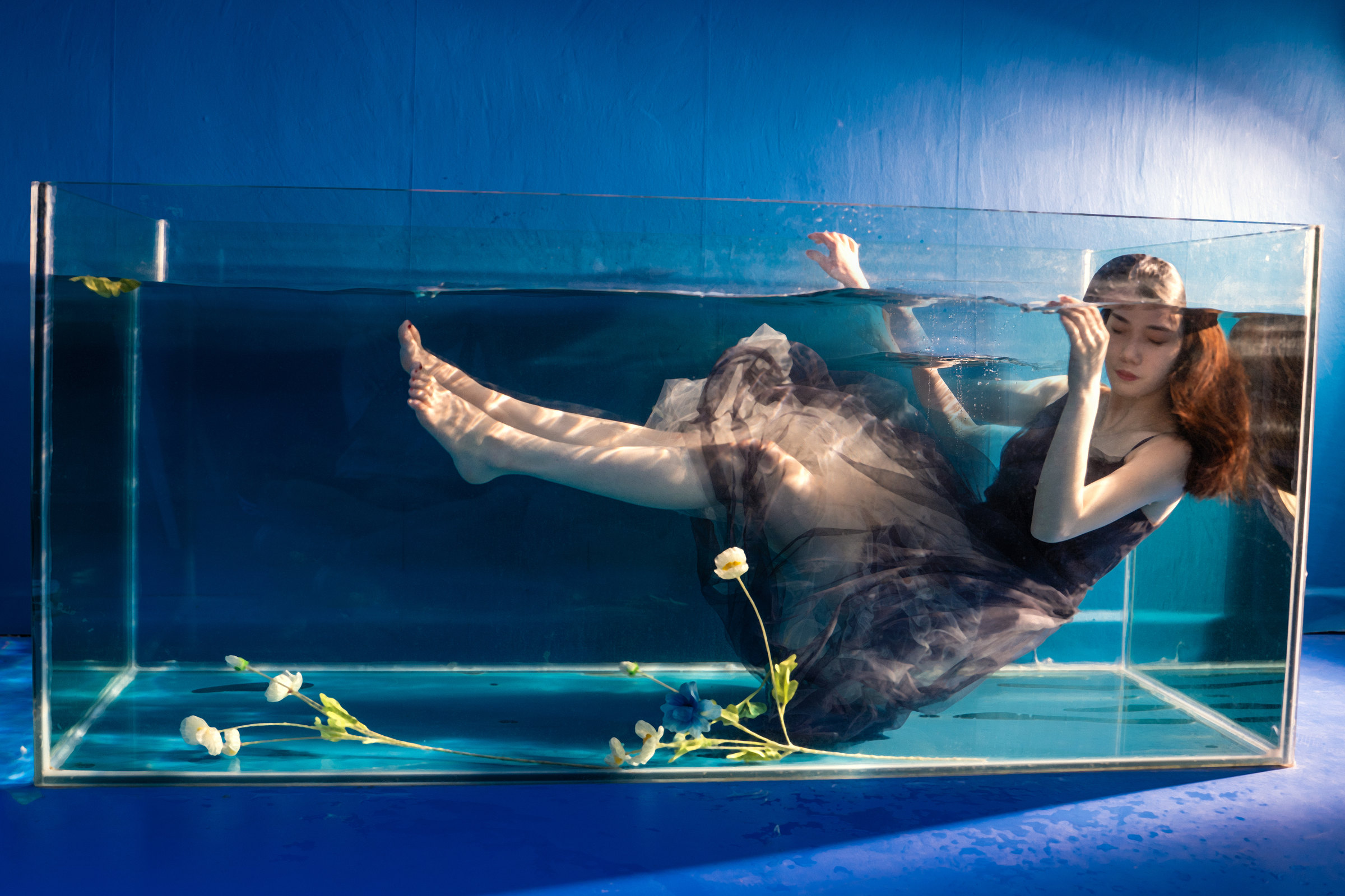 A woman enclosed inside a transparent water tank, from the Misread project