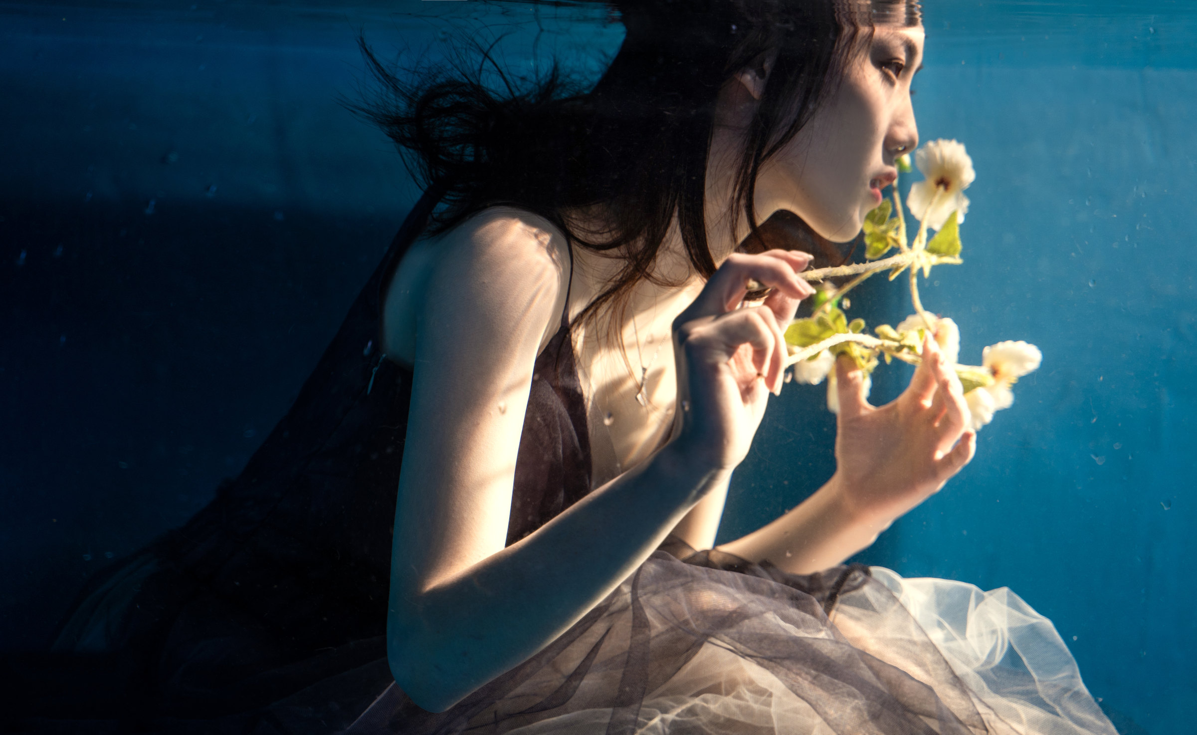 A woman holding white flowers close to her face
