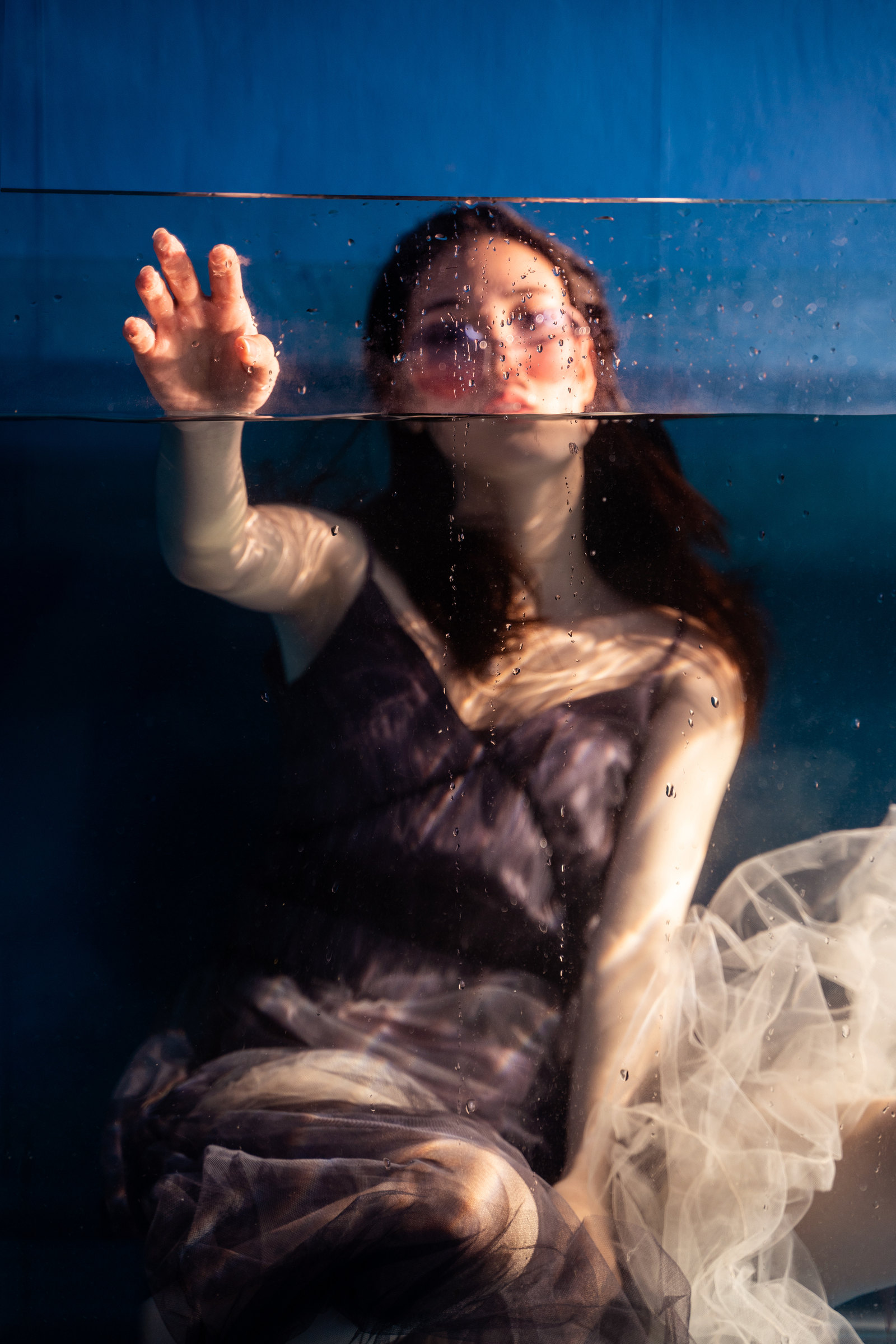 A woman raises her hands through the waterline