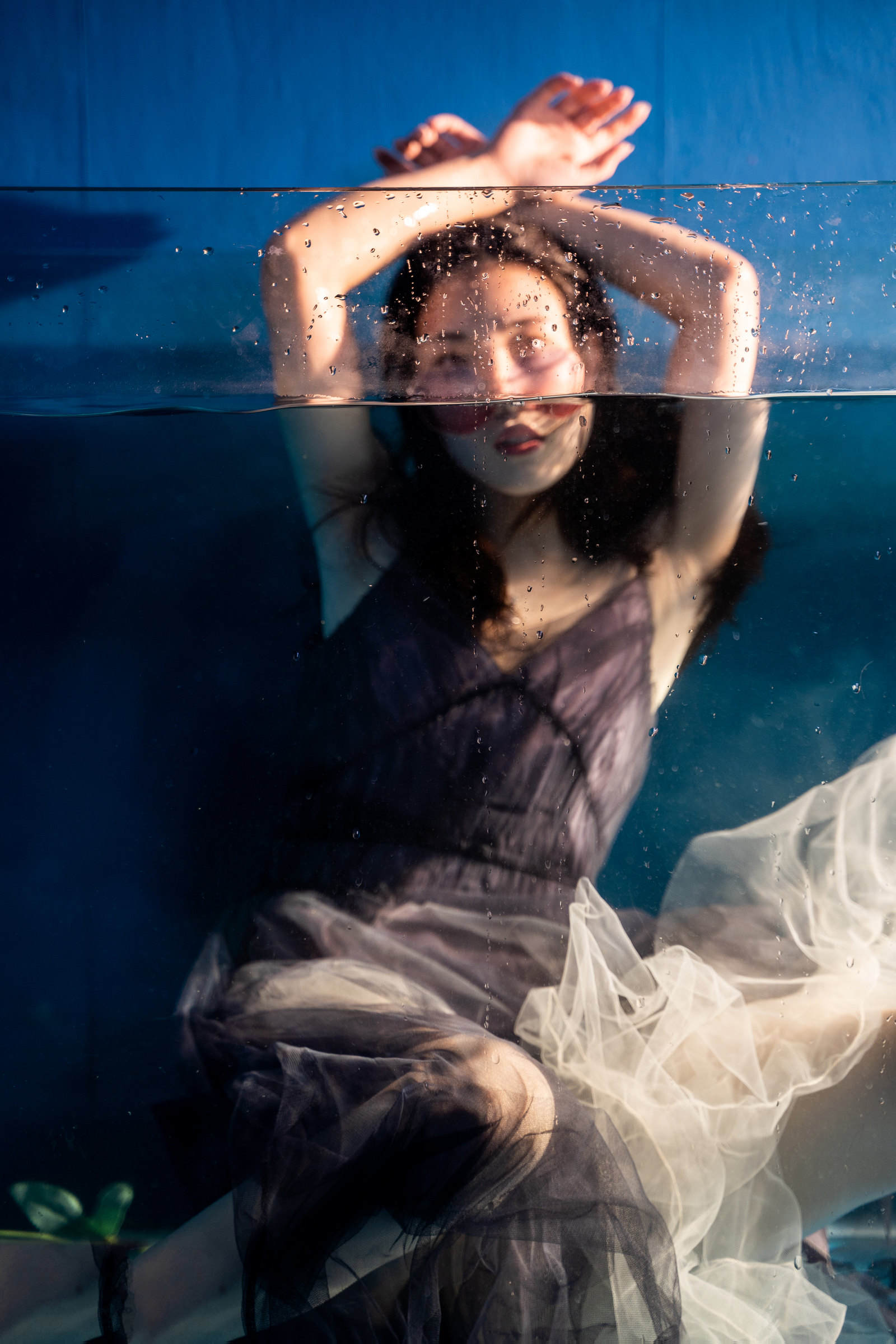 A woman presses her arms against the glass and waterline