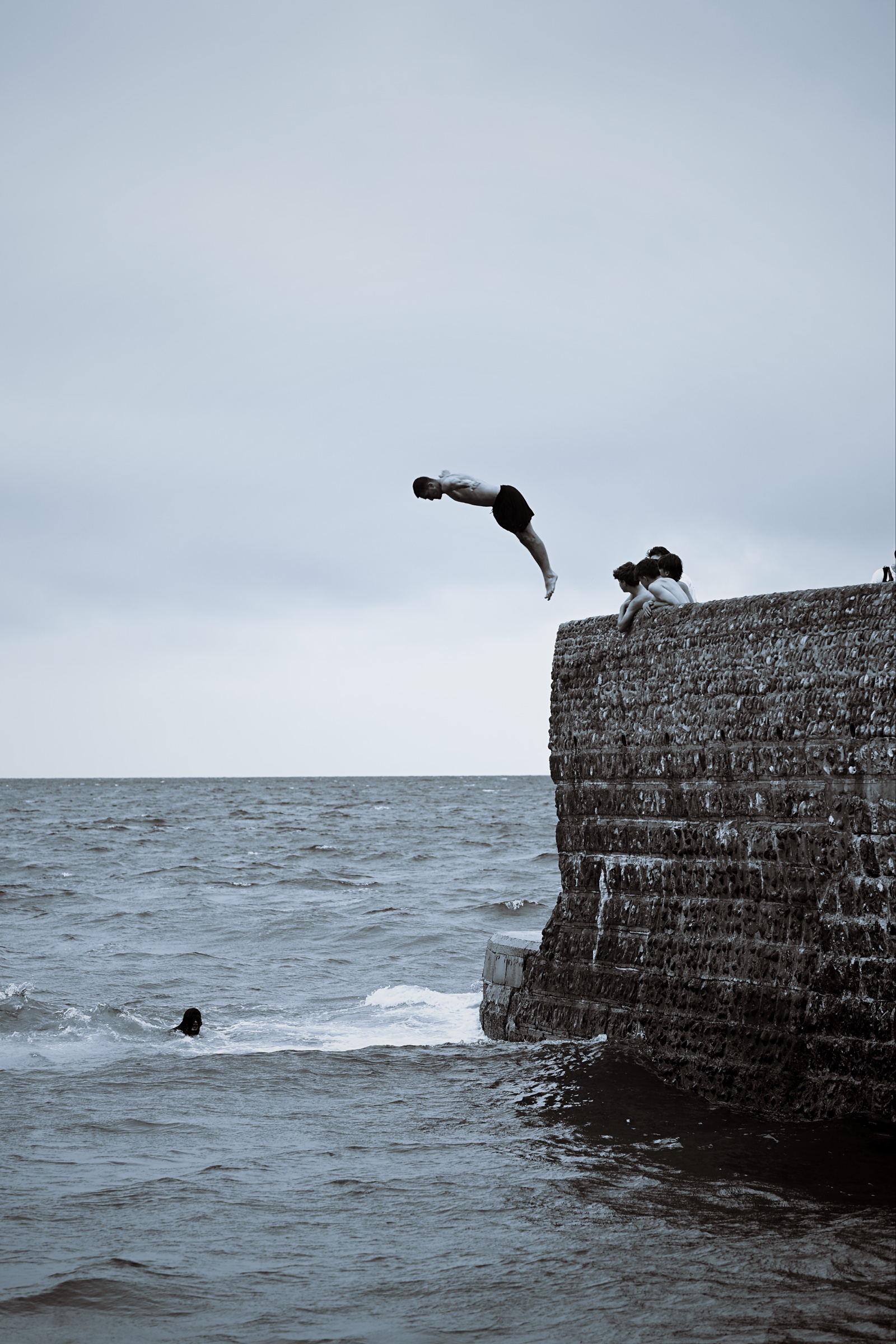 A young man begins a backward rotation above the wall