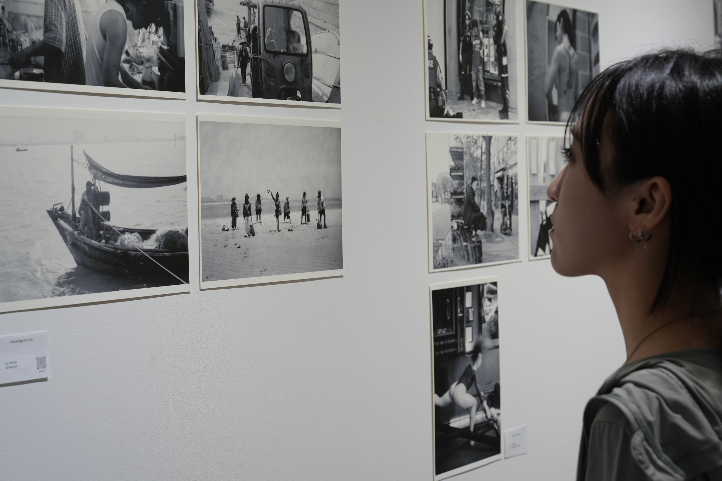 A visitor viewing photographs in The Grey Area exhibition at Deadbooks Gallery