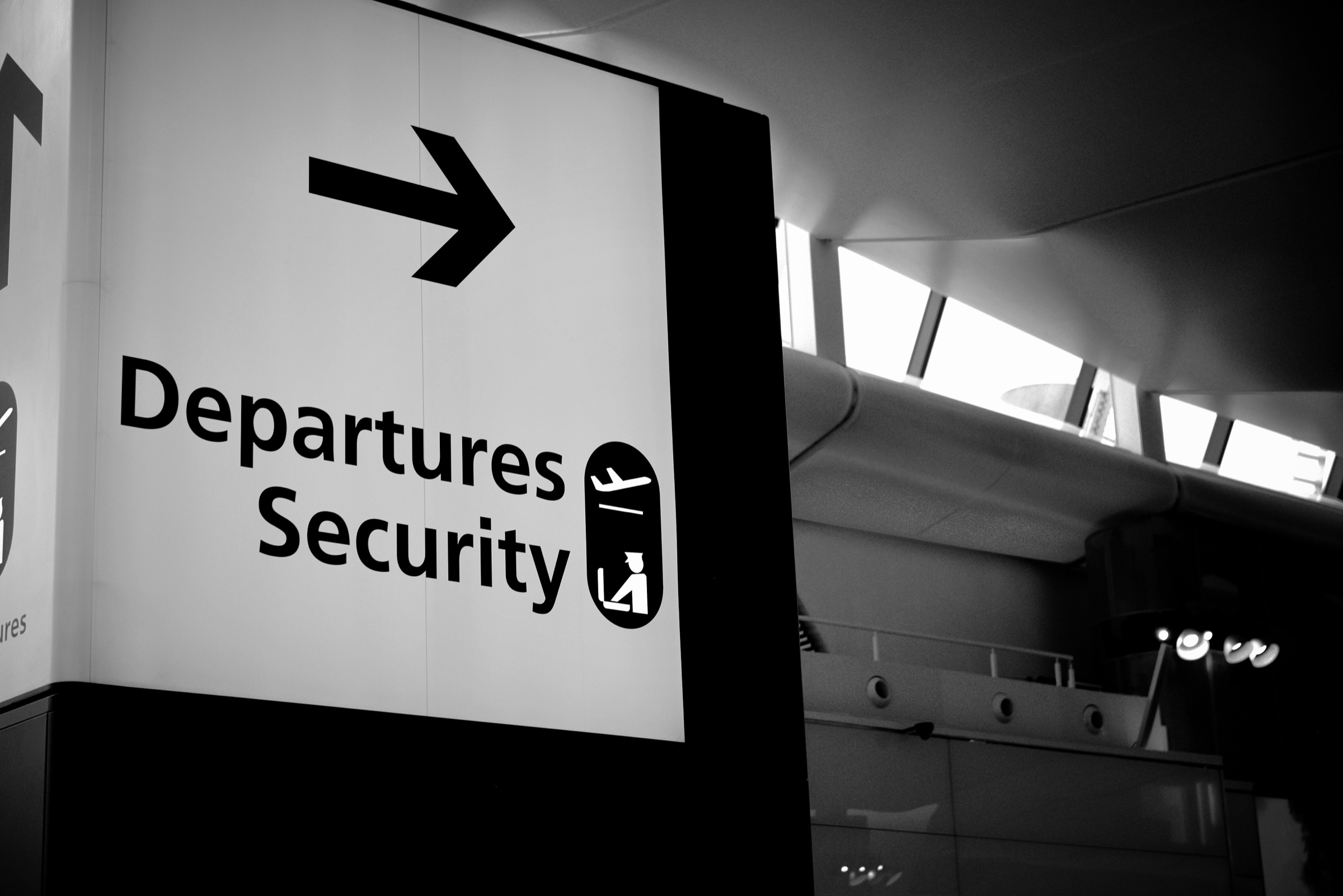 A Departures and Security sign inside a transport terminal, from Threshold